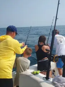 Family fishing charter in Murrells Inlet, learning to reel in a fish.
